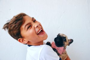 Young smiling boy holding a puppy