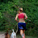 Jogger running with two dogs